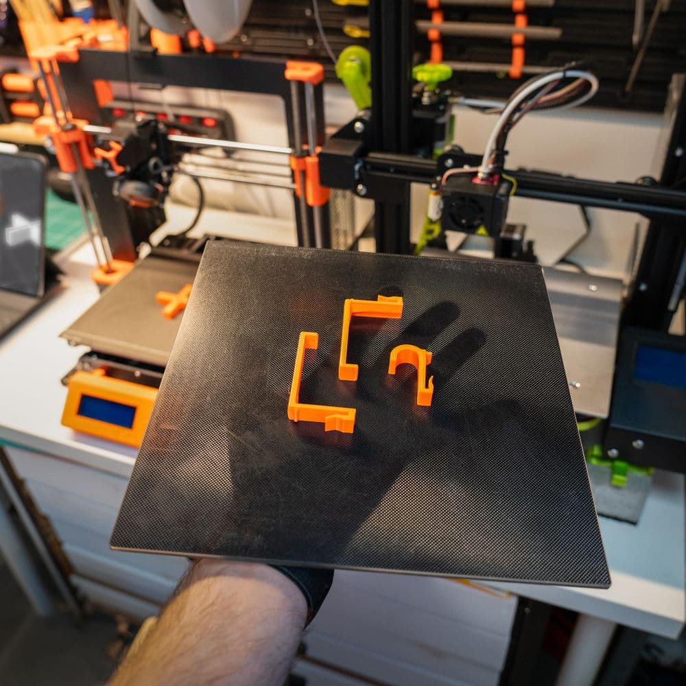 Custom 3D printed cable clips on a print bed